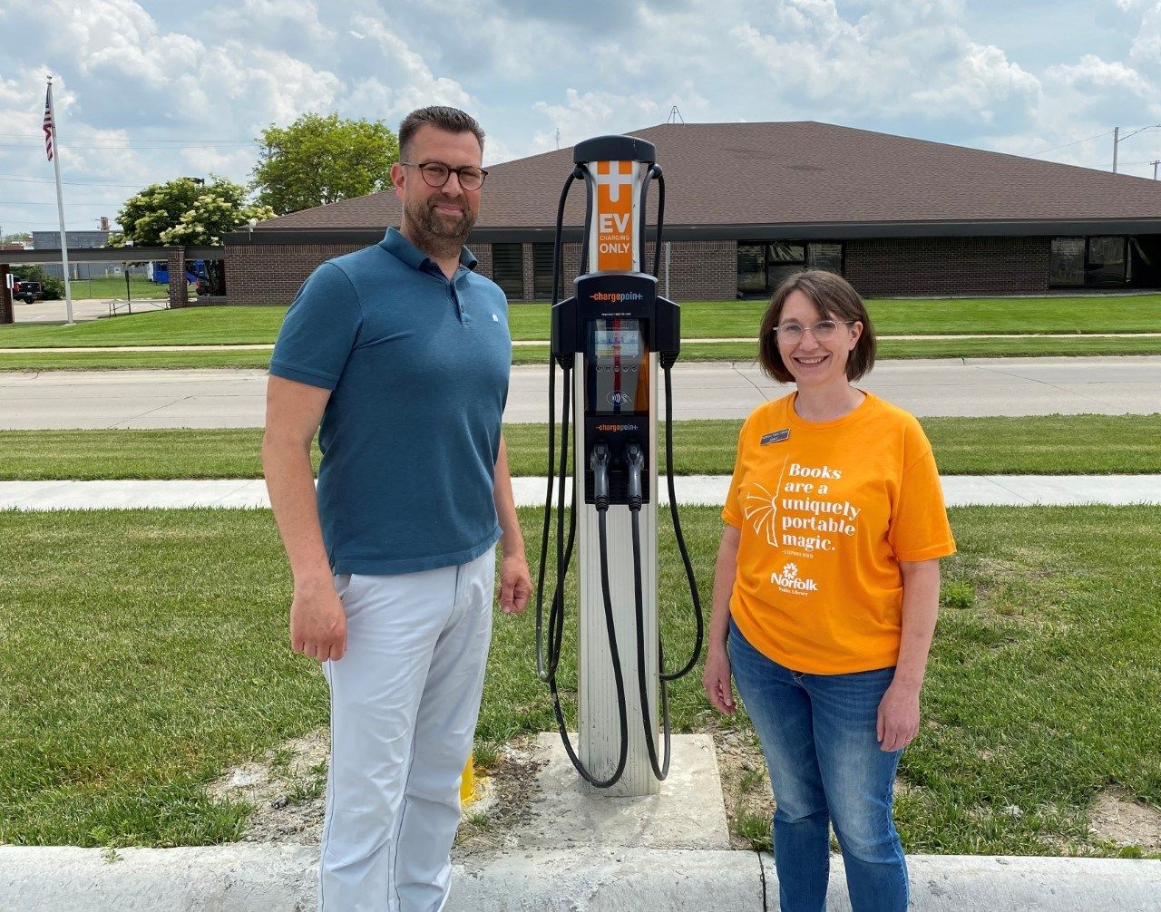 Mayor Josh Moenning and Library Director Jessica Chamberlain standing next to the new EV Charger.
