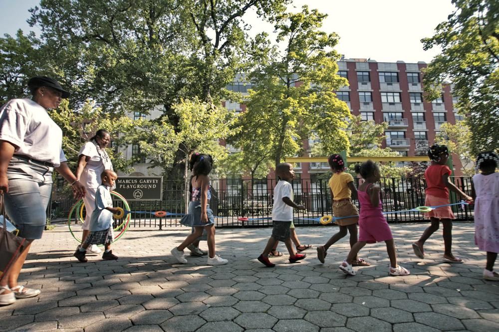 Children from a nearby daycare are escorted in Marcus Garvey Park in the Harlem neighborhood of New York Wednesday, Aug. 1, 2007.