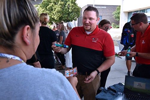 Kenny Wurdinger, information technology instructor at Northeast Community College, stamps the card of a student after she visited the eSports table at the College’s annual Cheers to Leadership Root Beer Kegger Thursday.