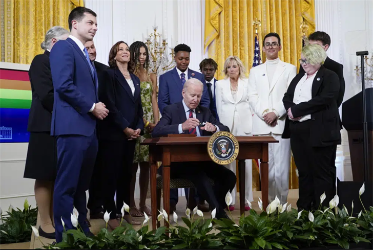 President Joe Biden signs an executive order at an event to celebrate Pride Month in the East Room of the White House, June 15, 2022, in Washington.
