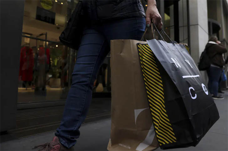 A shopper carries bags down Fifth Avenue on Black Friday, Nov. 25, 2022, in New York. Holiday sales rose as shoppers showed some resilience during the most important shopping season despite surging prices on everything from food to rent.