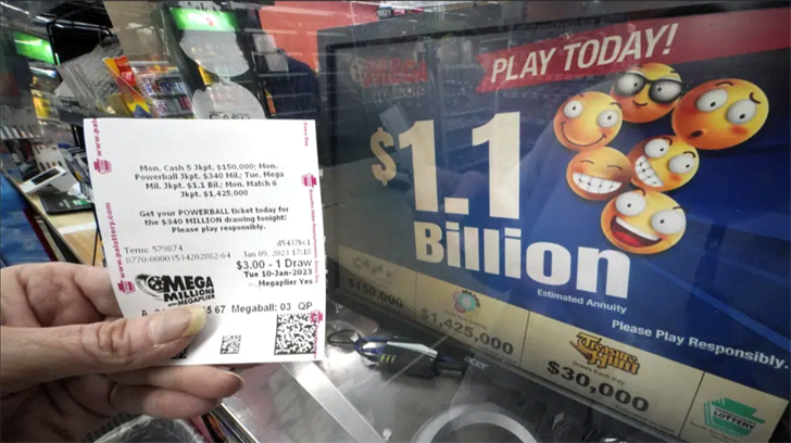 A Mega Millions customer displays her ticket for the estimated jackpot of $1.1 Billion at the Fuel On Convenience Store in Pittsburgh, Monday, Jan. 9, 2023.