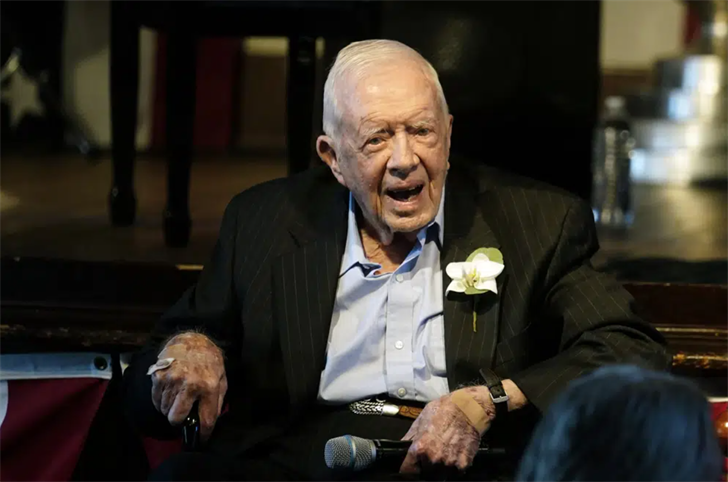 Former President Jimmy Carter reacts as his wife Rosalynn Carter speaks during a reception to celebrate their 75th wedding anniversary, July 10, 2021, in Plains, Ga.