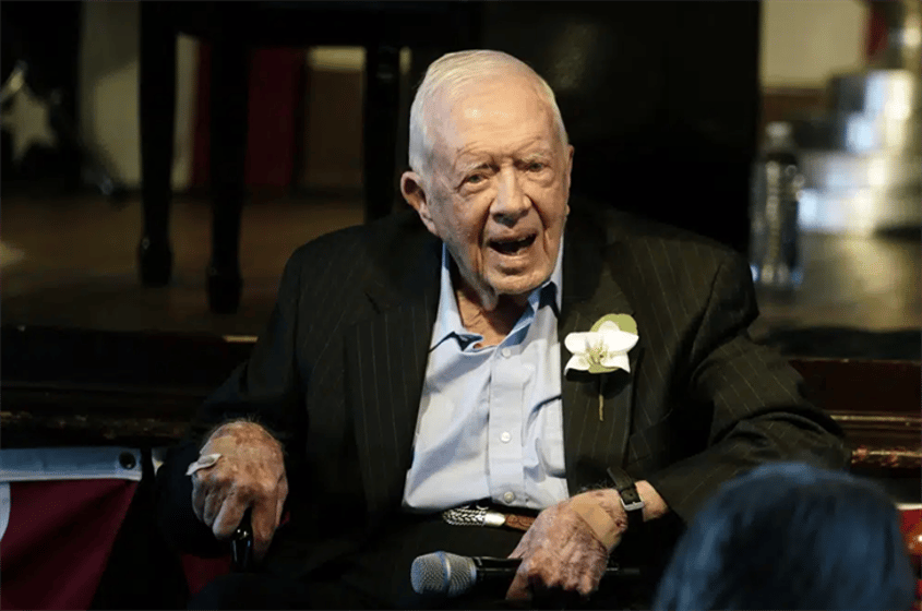 Former President Jimmy Carter reacts as his wife Rosalynn Carter speaks during a reception to celebrate their 75th wedding anniversary, July 10, 2021, in Plains, Ga.