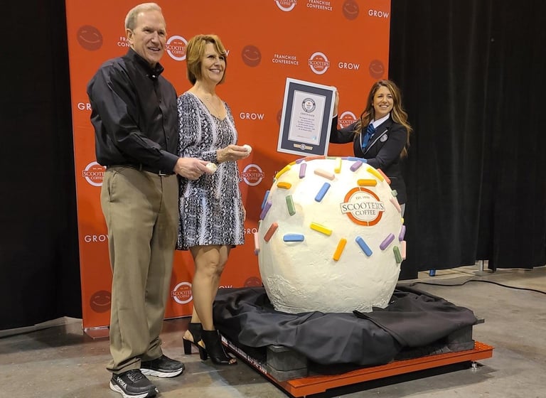 Don and Linda Eckles, who founded Scooter's Coffee in 1998 in Bellevue, receive certification from Guinness World Records official adjudicator Brittany Dunn.