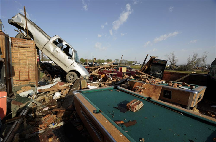 A pickup truck rests on top of a restaurant cooler at Chuck's Dairy Cafe in Rolling Fork, Miss., Saturday, March 25, 2023.