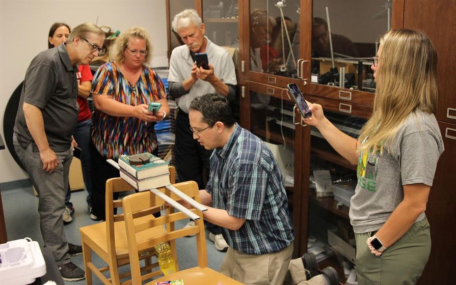 Dr. Adam Davis (center), Professor of Physics at Wayne State College, makes an adjustment on a center of mass demonstration during Wayne State’s first Summer Physics Demonstrations Workshop for area middle school and high school teachers.