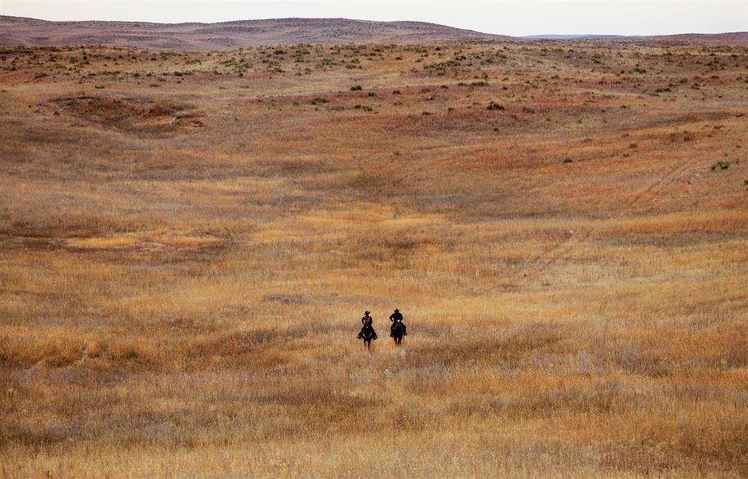Ranch hand Mike Goodman, left, and ranch manager Frank Thompson ride through the prairie grass on a ranch located north of Keystone, Nebraska.