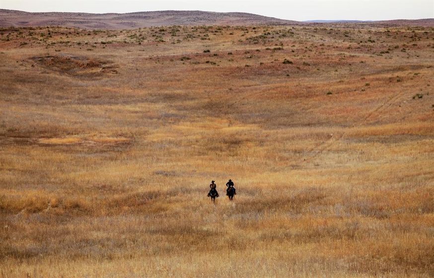 Ranch hand Mike Goodman, left, and ranch manager Frank Thompson ride through the prairie grass on a ranch located north of Keystone, Nebraska.