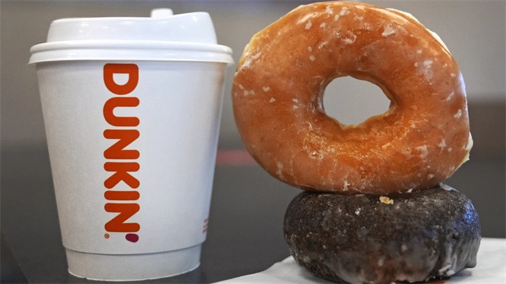 Two donuts and a cup of coffee rest on a counter at a Dunkin' location, Friday, Jan. 10, 2025, in Derry, N.H.