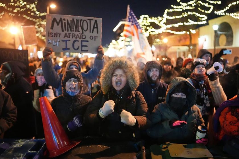 Protesters chant and bang on trash cans as they stand behind a makeshift barricade during a protest in response to the death of 37-year-old Alex Pretti, who was fatally shot by a U.S. Border Patrol officer earlier in the day, Saturday, Jan. 24, 2026, in M